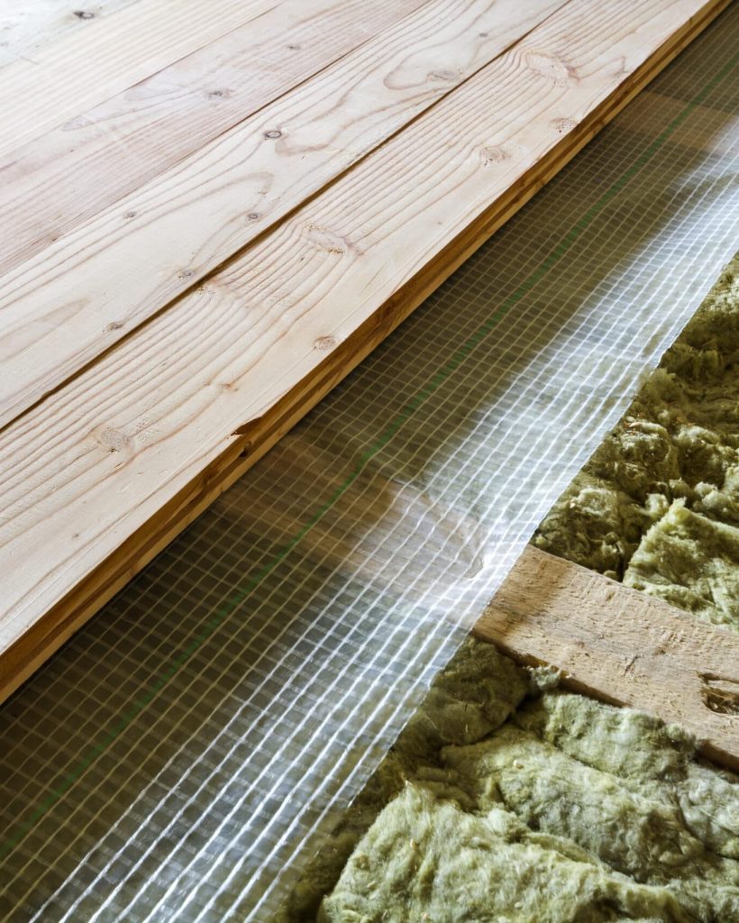 Installation of new floor of wooden natural planks and mineral wool insulation for isolation and keeping warmth. Modern technologies, warm comfortable house and eco-friendly insulation concept.