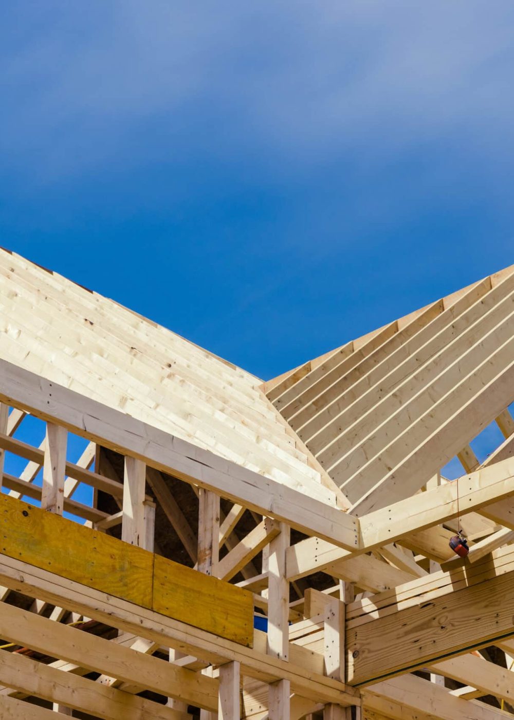A new residential construction home framing with a roof view