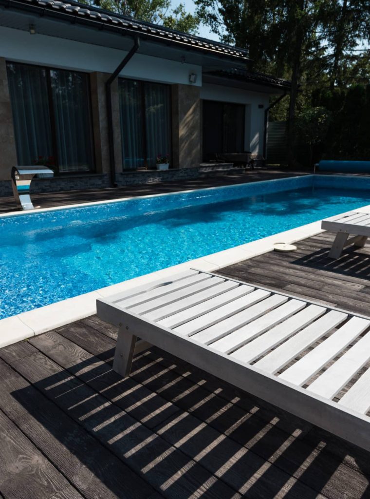 view of house exterior, swimming pool with sunbeds